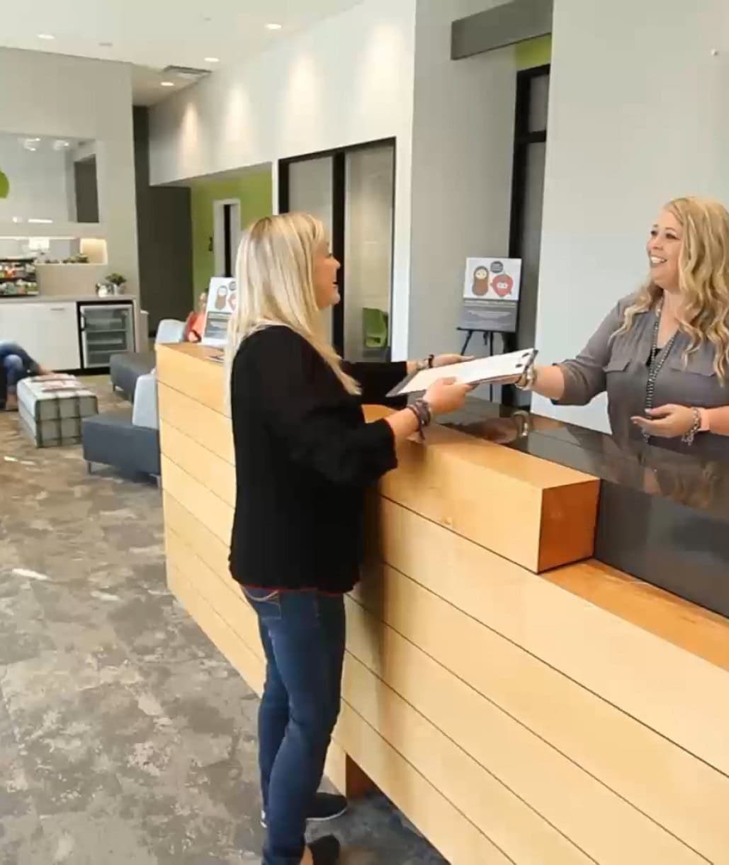 Team member helping patient at front desk