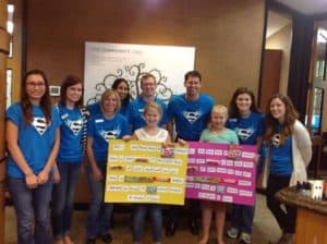 Team members and two children holding up posters